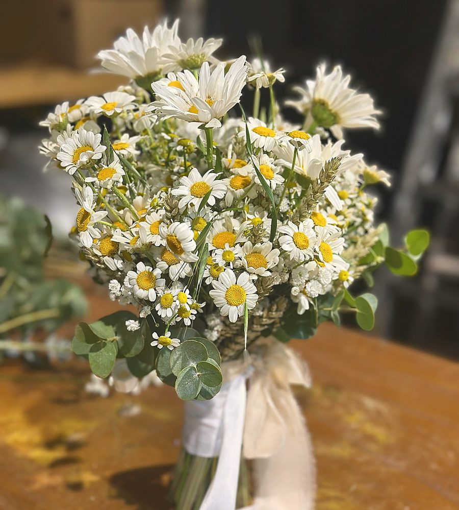 Fleuriste tenant un bouquet de roses blanches